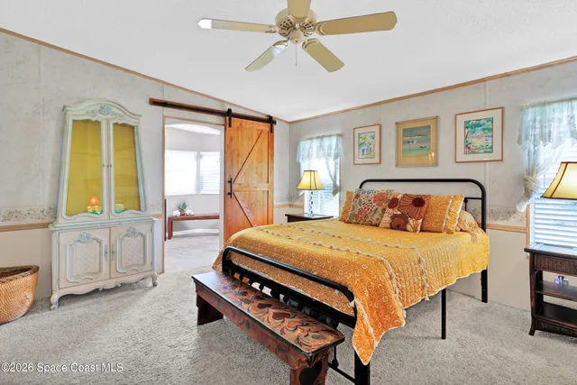 a bedroom with a bed a table and with potted plant