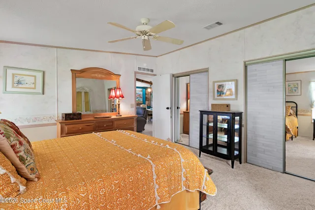 a spacious bedroom with a bed a dresser and book shelf