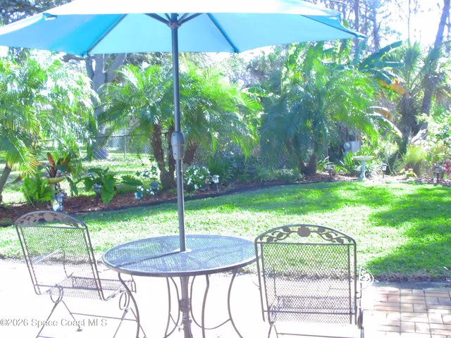 a backyard of a house with table and chairs