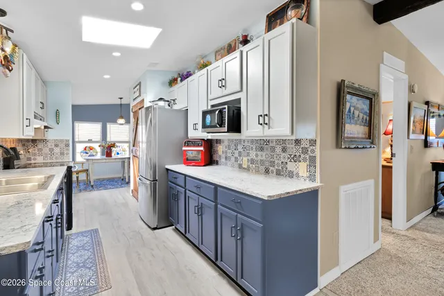 a kitchen with stainless steel appliances kitchen island granite countertop a refrigerator and a stove top oven