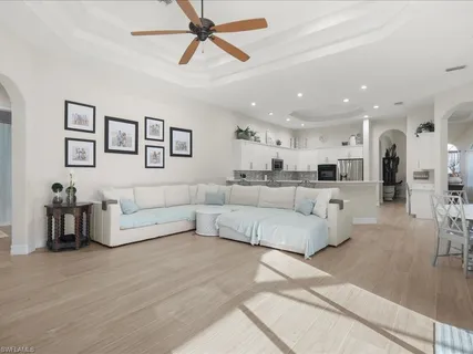 a living room with furniture and a view of kitchen