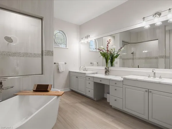 a bathroom with a double vanity sink a mirror and a bathtub