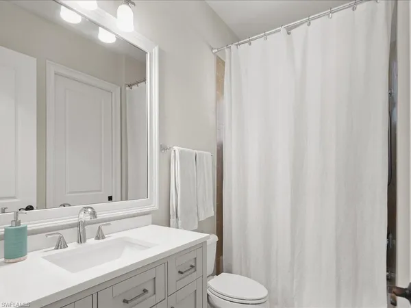 a bathroom with a sink a toilet and shower curtain