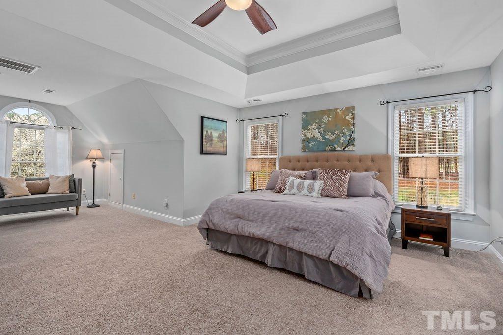 10400 Old Warden Road Raleigh, NC 27615 - Photo 19 of 30 a spacious bedroom with a bed and a chandelier