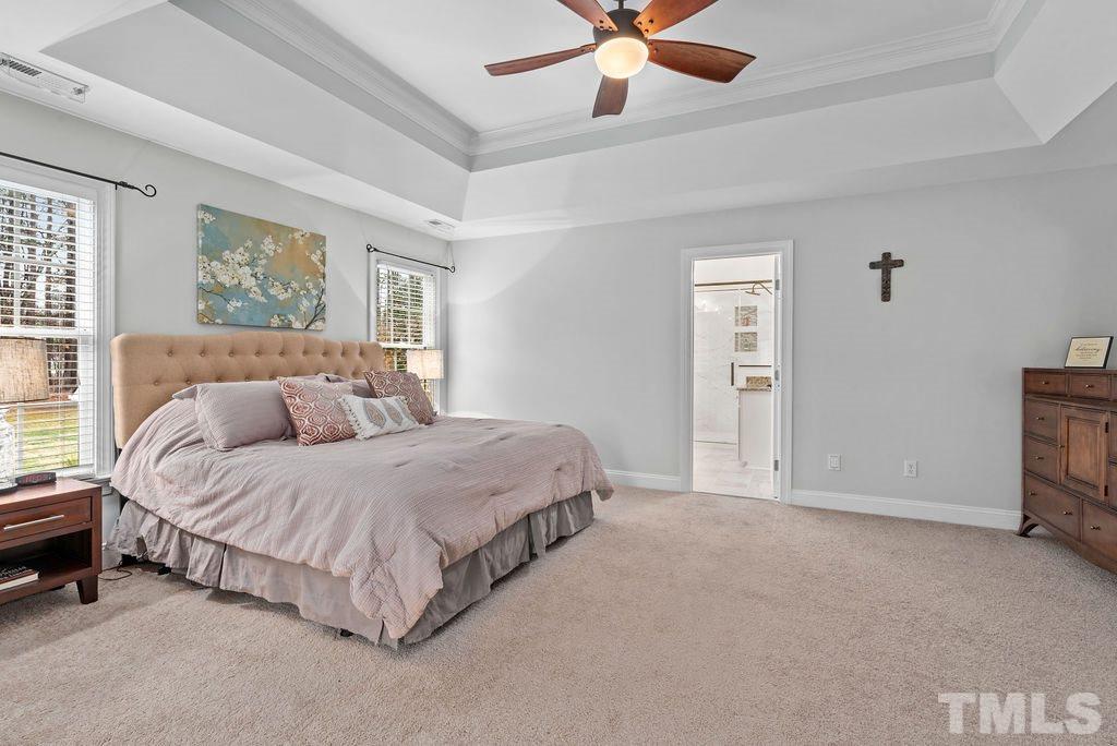 10400 Old Warden Road Raleigh, NC 27615 - Photo 20 of 30 a spacious bedroom with a bed and a chandelier