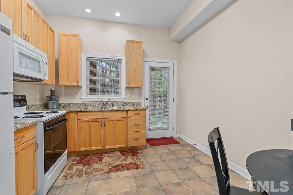 10400 Old Warden Road Raleigh, NC 27615 - Photo 24 of 30 a kitchen with granite countertop a sink stove and cabinets
