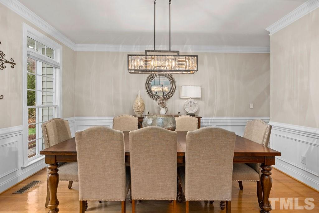 10400 Old Warden Road Raleigh, NC 27615 - Photo 6 of 30 a view of dining room and livingroom with furniture wooden floor a rug a fireplace and a chandelier