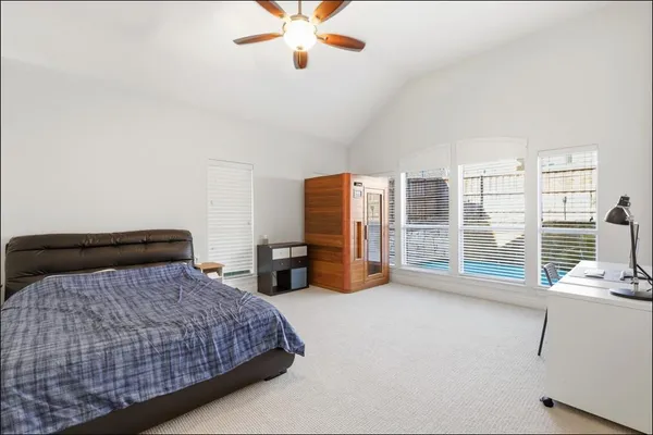 a bedroom with a large bed and a chandelier