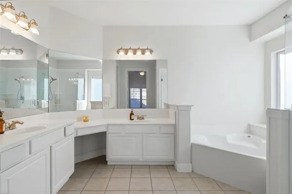 a view of a double vanity sink mirror and cabinets