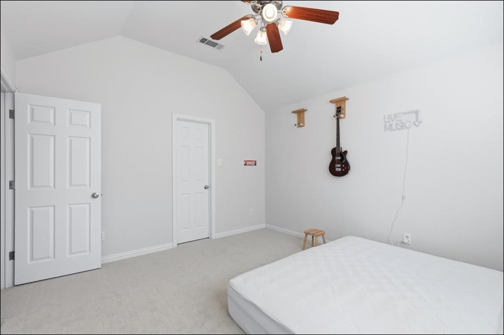 1905 Natchez Trace Allen, TX 75013 - Photo 23 of 26 a bedroom with a white bed and a chandelier