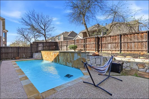 a view of a roof deck with couches chairs and wooden fence