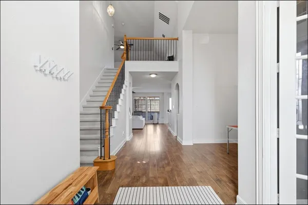 a view of a hallway with wooden floor and staircase