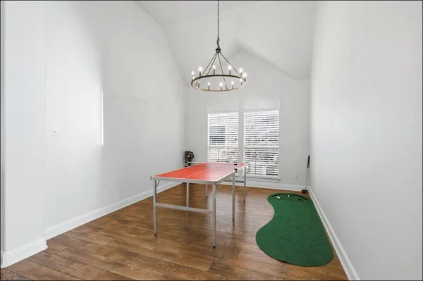 a view of a room with wooden floor table and chairs