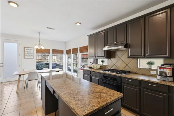 a kitchen with stainless steel appliances granite countertop a stove a sink dishwasher and cabinets with wooden floor