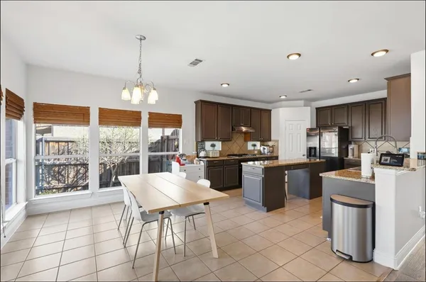a kitchen with a dining table chairs and view of living room