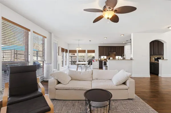 a living room with furniture kitchen view and a large window