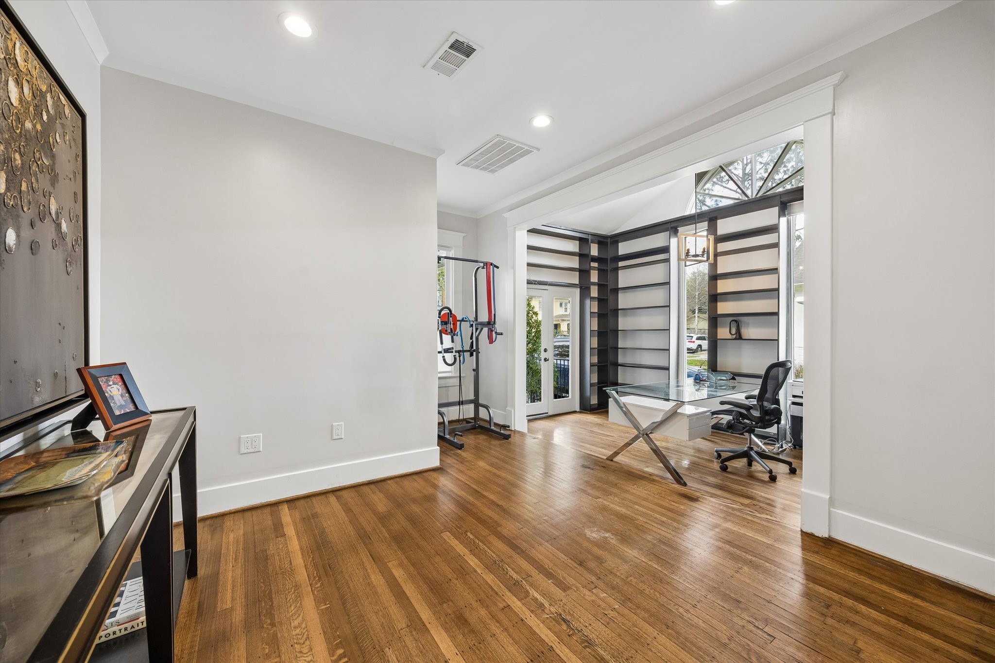 1307 Marshall Street Houston, TX 77006 - Photo 16 of 23 The front bedroom or office has a private entrance and walls of bookshelves. Currently used as a home office and gym, this space is very versatile.