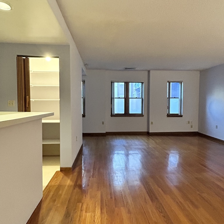 28 Parkman Street, Unit 2 Brookline, MA 02446 - Photo 3 of 11 an empty room with wooden floor and windows