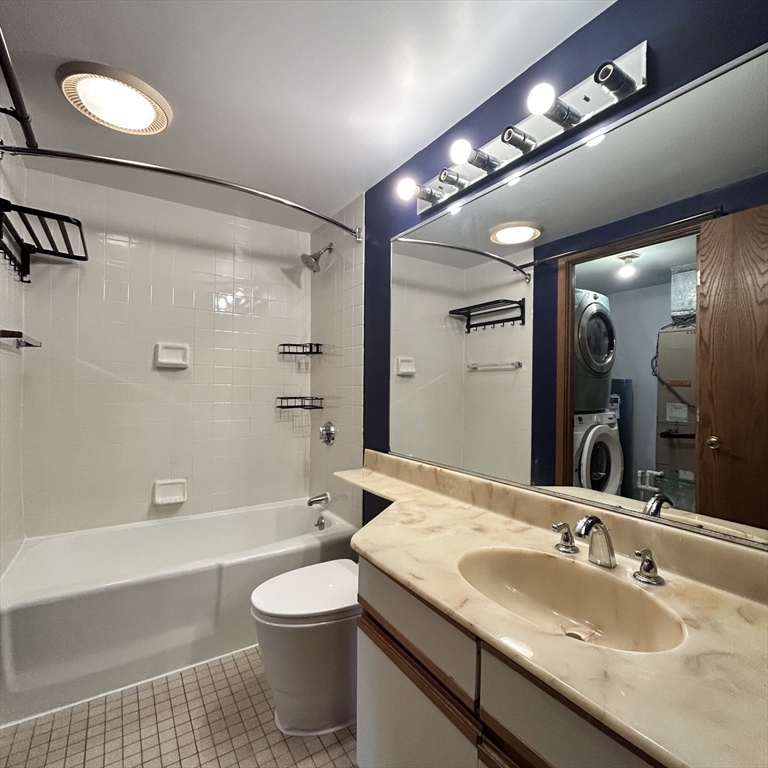 28 Parkman Street, Unit 2 Brookline, MA 02446 - Photo 5 of 11 a bathroom with a granite countertop sink a toilet a mirror and shower