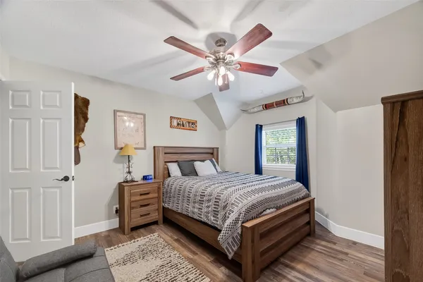 a bedroom with a bed window and a flat screen tv