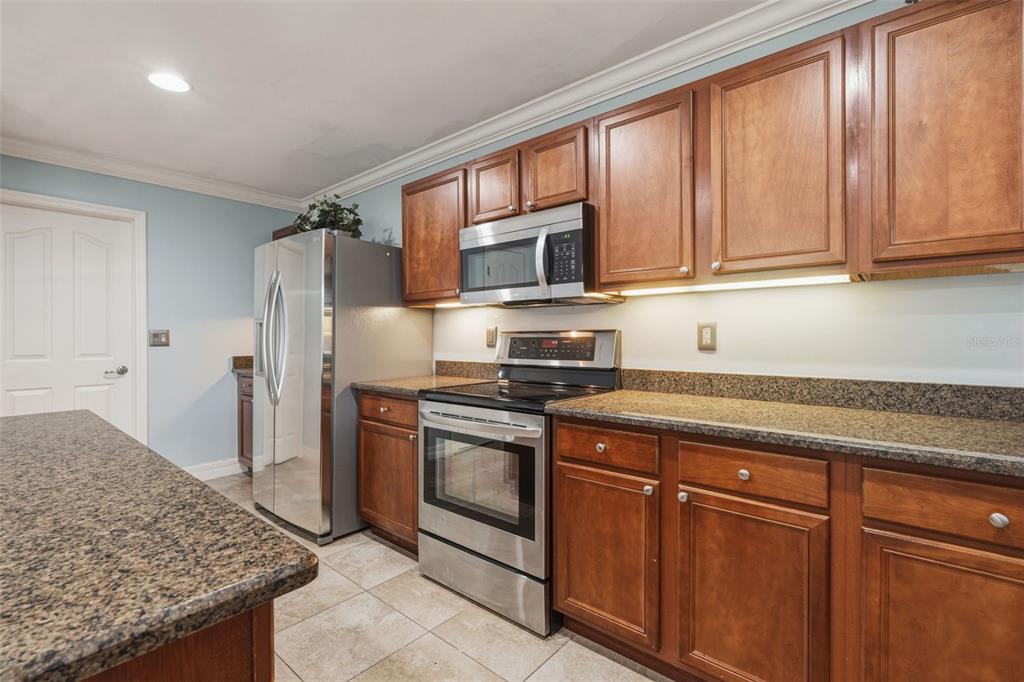 25134 Palisade Road Punta Gorda, FL 33983 - Photo 30 of 58 a kitchen with stainless steel appliances granite countertop a stove microwave and refrigerator