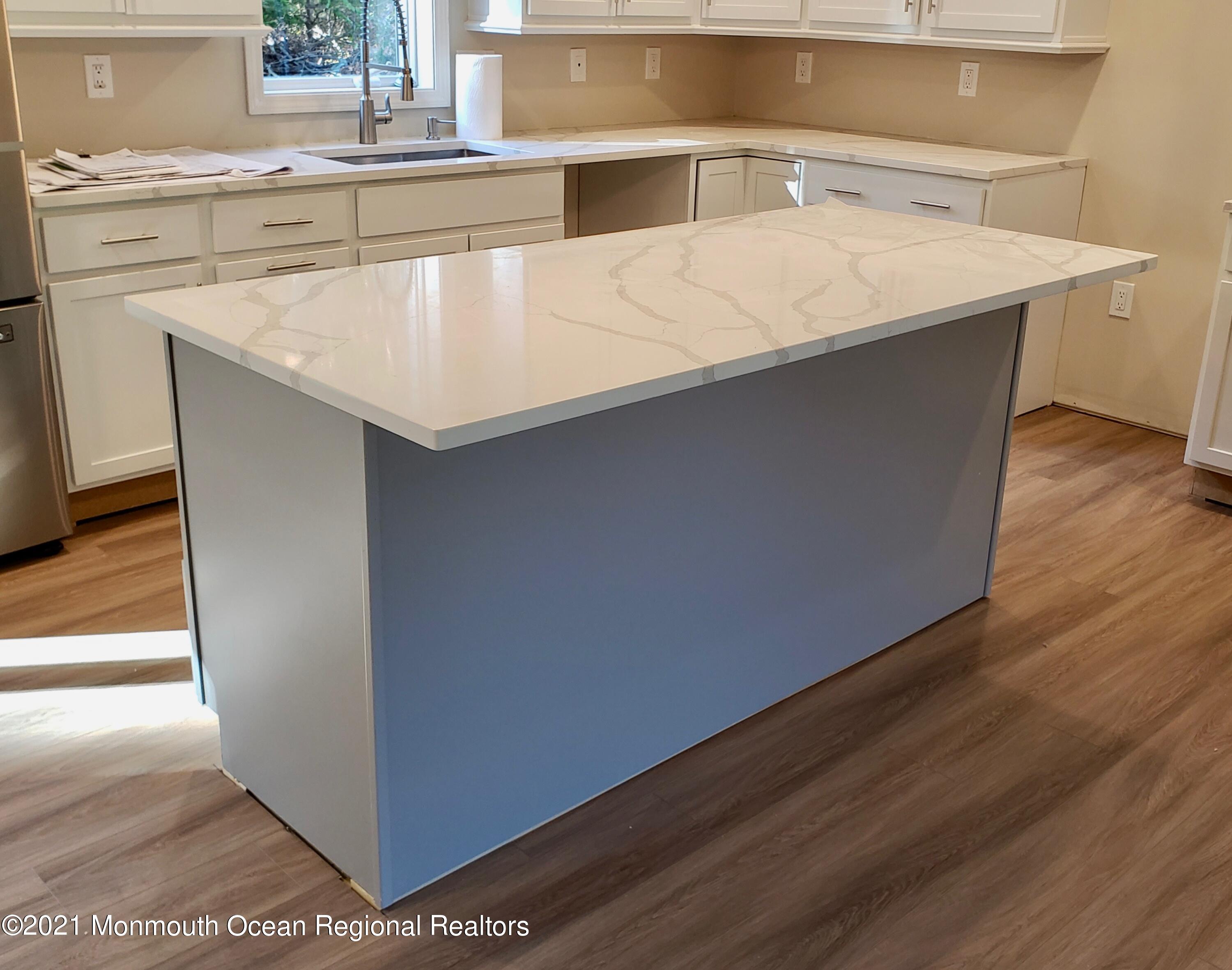154 Jackson Mills Road Freehold, NJ 07728 - Photo 8 of 19 a kitchen with kitchen island a sink and wooden floor