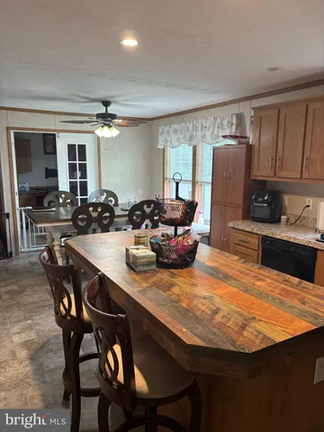 a kitchen with stainless steel appliances granite countertop a table chairs and a refrigerator