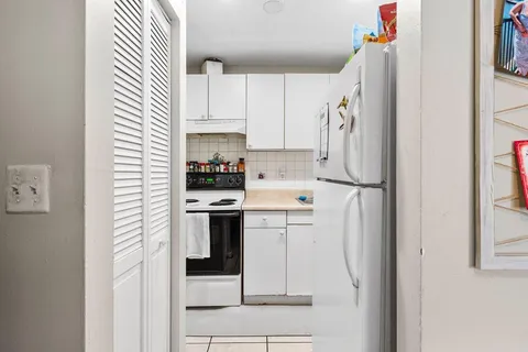 a kitchen with a refrigerator a sink and cabinets