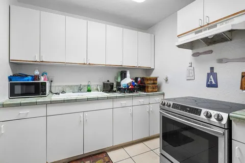 a kitchen with granite countertop white cabinets and white appliances