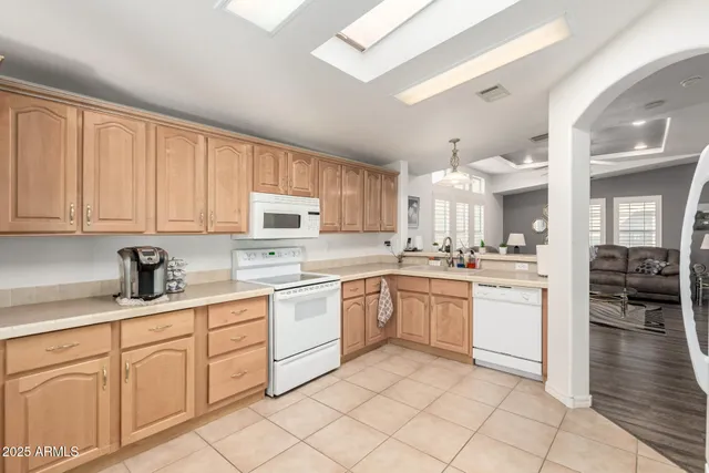 a kitchen with granite countertop white cabinets white stainless steel appliances with a sink and dishwasher