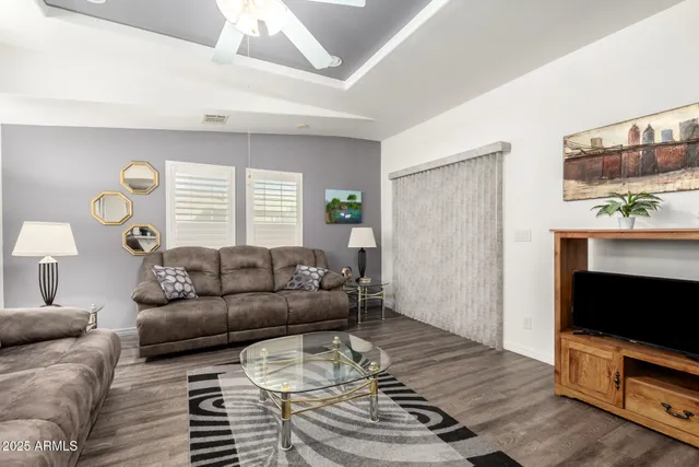 a living room with furniture a flat screen tv and a window