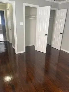 an empty room with wooden floor and entrance