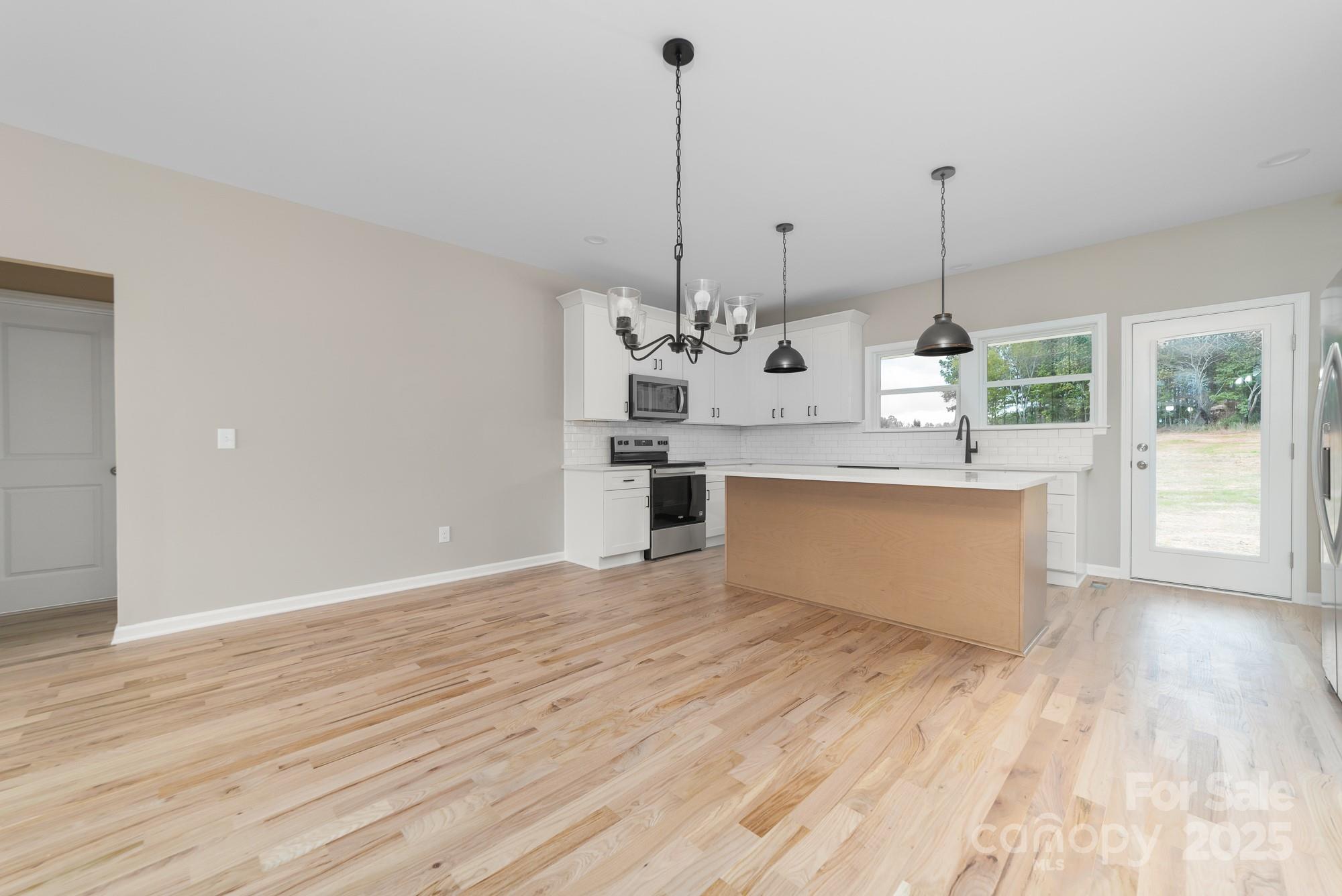 6203 Flay Road Cherryville, NC 28021 - Photo 16 of 34 a view of a kitchen with kitchen island a counter space a sink and wooden floor