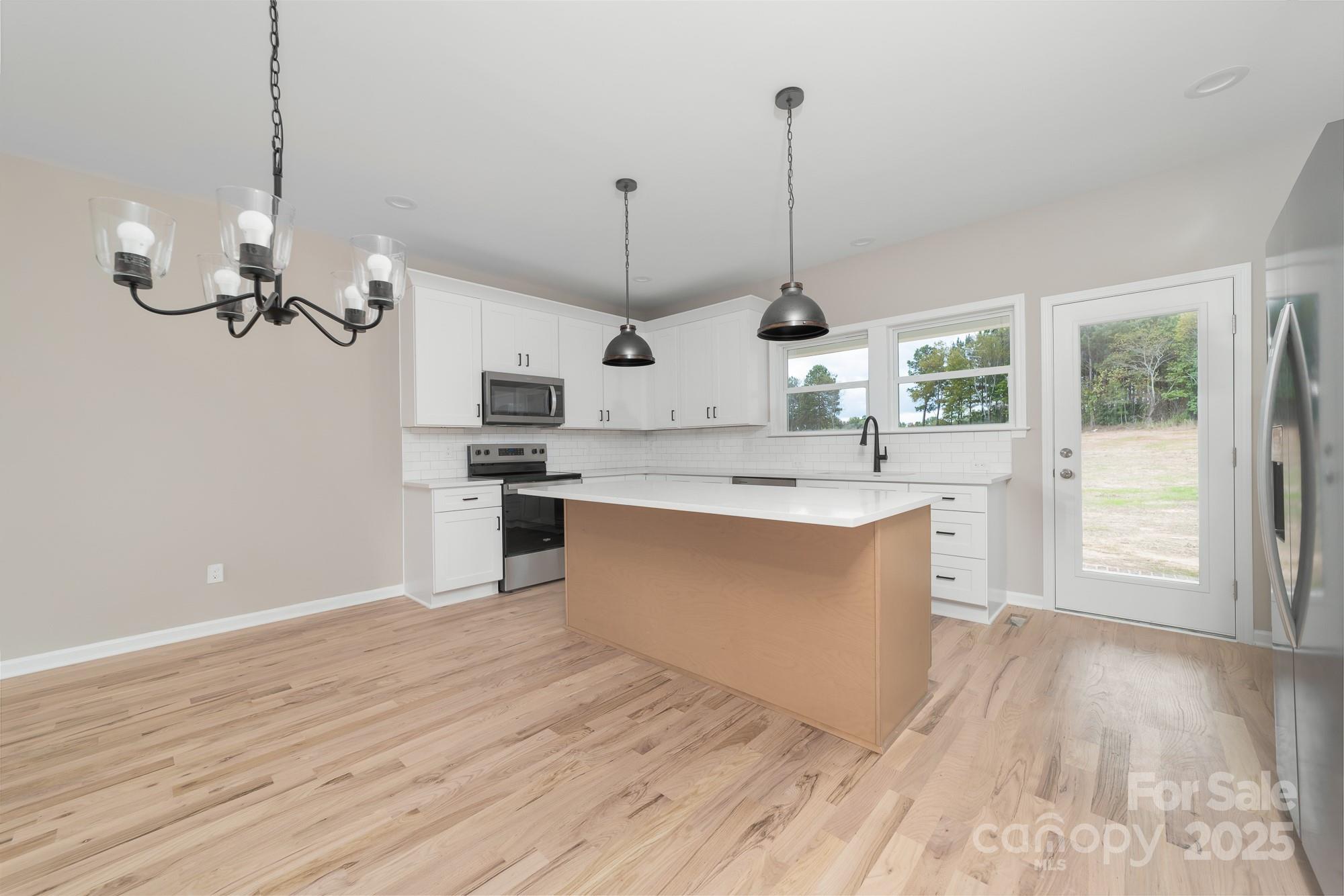 6203 Flay Road Cherryville, NC 28021 - Photo 20 of 34 a large kitchen with stainless steel appliances granite countertop a sink a oven a refrigerator and a wooden floor