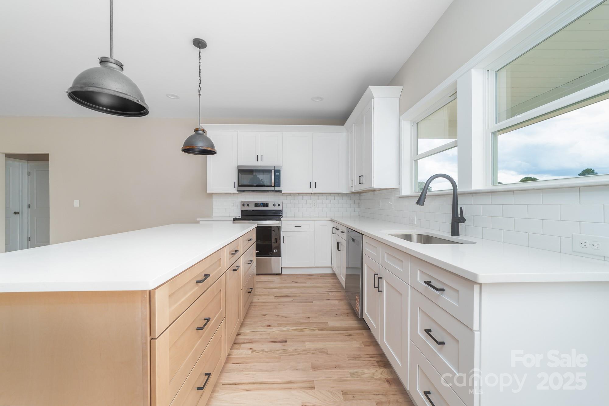 6203 Flay Road Cherryville, NC 28021 - Photo 22 of 34 a kitchen with stainless steel appliances a sink a stove and a wooden floors