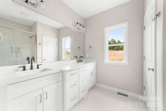 a spacious bathroom with double sink and a mirror