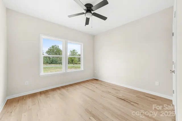 a view of a room with a window and a ceiling fan