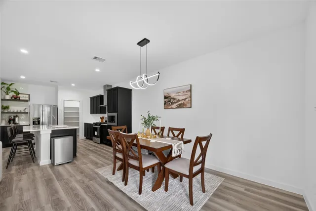 a living room with stainless steel appliances furniture and a flat screen tv