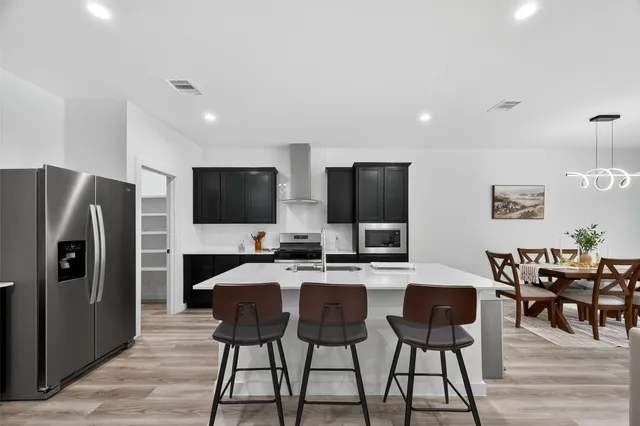 a kitchen with stainless steel appliances granite countertop a refrigerator and a sink