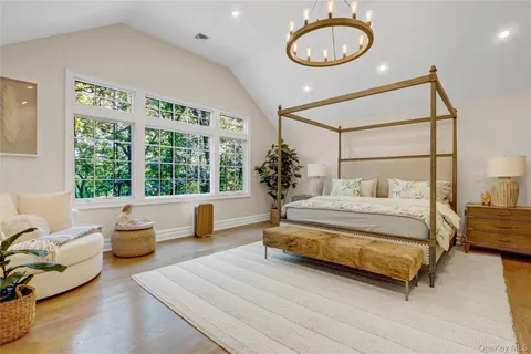 a bedroom with a bed a couch and a large window