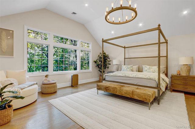 a bedroom with a bed a couch and a large window