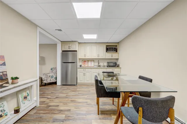 a kitchen with stainless steel appliances granite countertop a refrigerator a stove a sink dishwasher and white cabinets with wooden floor