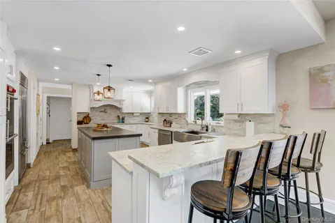 a kitchen with stainless steel appliances kitchen island granite countertop a sink and cabinets
