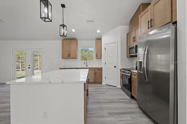 a kitchen with kitchen island a counter top space appliances and cabinets