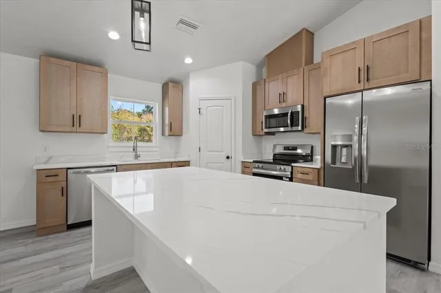 a kitchen with cabinets and stainless steel appliances