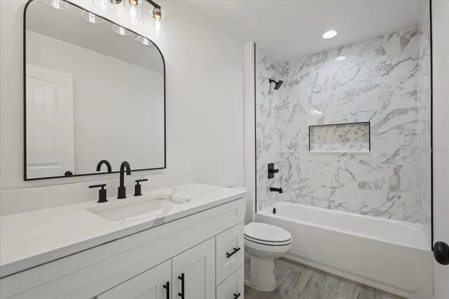 a bathroom with a sink a toilet and shower