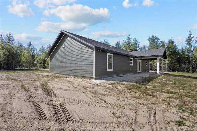 a backyard of a house with large trees and garage