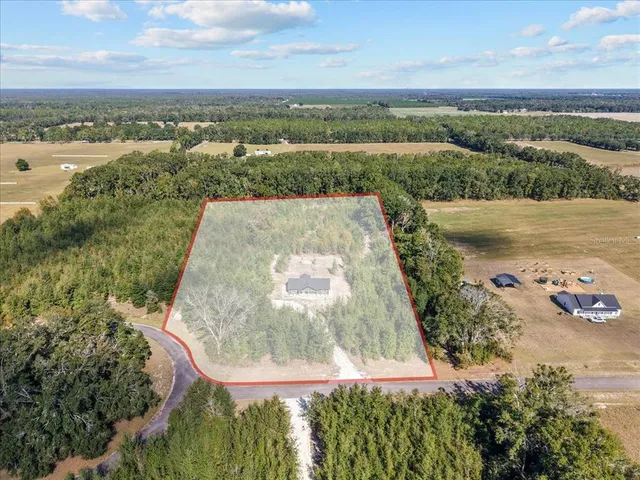 an aerial view of residential houses with outdoor space and river