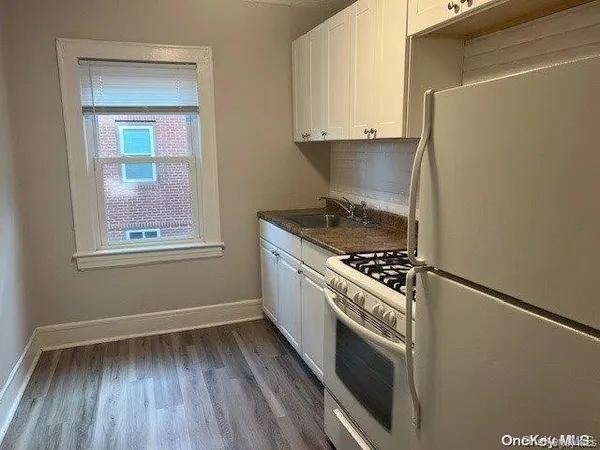 a kitchen with granite countertop a stove and a refrigerator