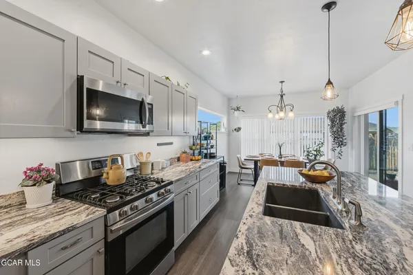 a bathroom with a granite countertop double vanity sink a mirror and a toilet